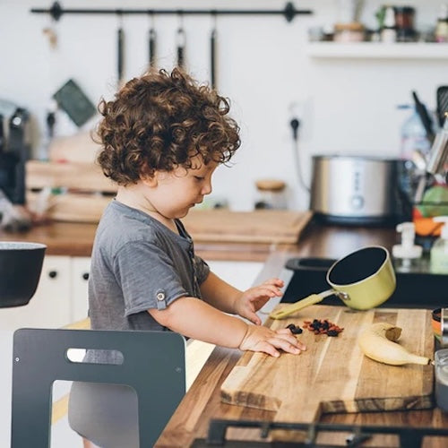 Child using toddler tower to be a great kitchen helper nz